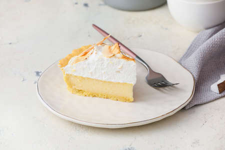 Plate with piece of tasty coconut pie on light backgroundの写真素材