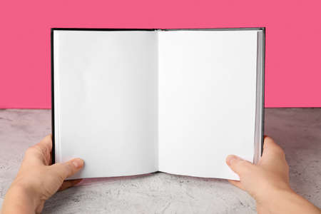 Woman holding blank book on color background, closeupの写真素材