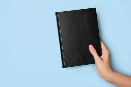 Woman holding book on color backgroundの写真素材