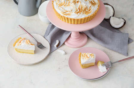 Plates with pieces of tasty coconut pie on light backgroundの写真素材