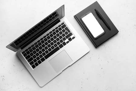 Composition with modern laptop and book on light backgroundの写真素材