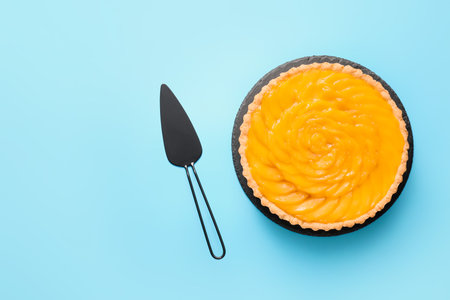 Tasty mango pie and spatula on color backgroundの写真素材