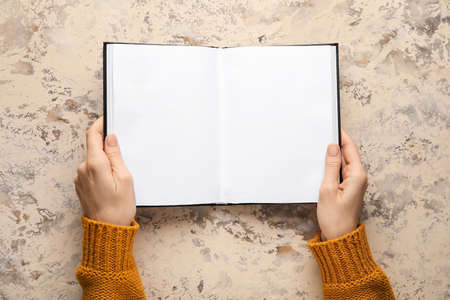 Woman holding blank book on grunge backgroundの写真素材