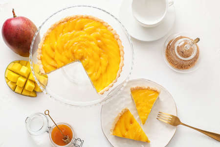Plates with tasty mango pie on light backgroundの写真素材