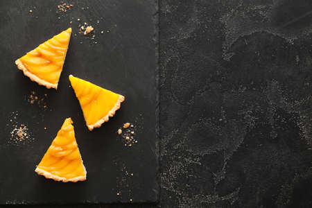 Pieces of tasty mango pie on dark backgroundの写真素材