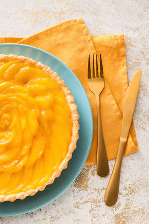 Plate with tasty mango pie on light backgroundの写真素材