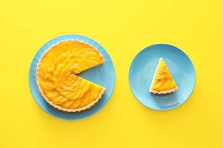 Plates with tasty mango pie on color backgroundの写真素材