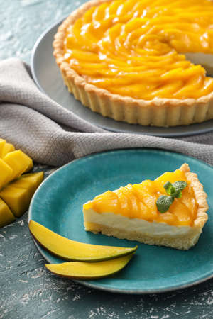 Plate with piece of tasty mango pie on color backgroundの写真素材