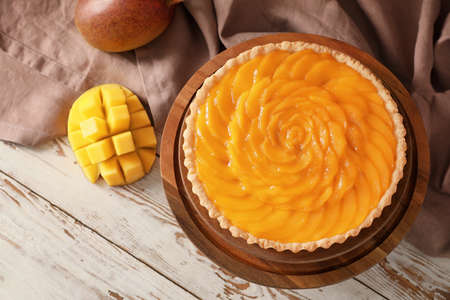 Plate with tasty mango pie on wooden backgroundの写真素材