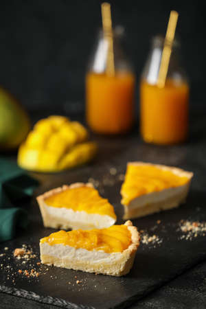Pieces of tasty mango pie on dark backgroundの写真素材