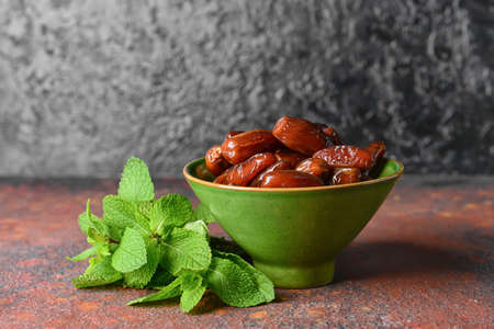 Bowl with sweet dried dates on grunge backgroundの写真素材