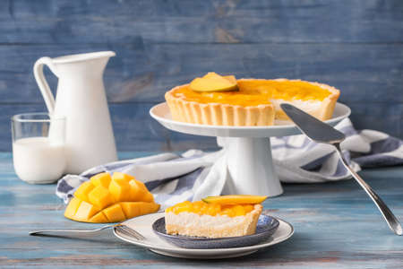 Plate with piece of tasty mango pie on color wooden backgroundの写真素材