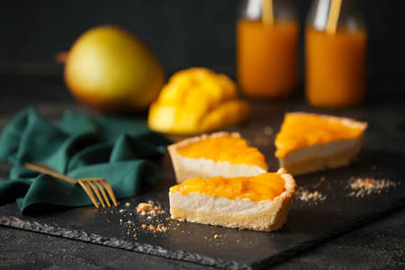 Pieces of tasty mango pie on dark backgroundの写真素材