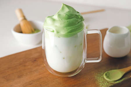 Cup of tasty dalgona matcha latte on table, closeup