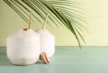 Fresh coconuts on color wooden background