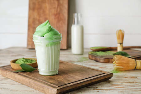 Composition with tasty dalgona matcha latte on wooden background