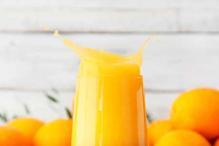 Glass of orange juice on light wooden backgroundの写真素材