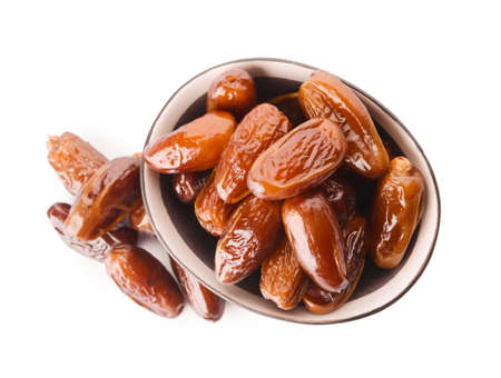 Bowl with sweet dried dates on white background
