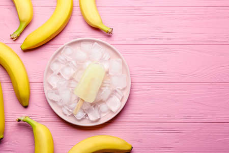 Plate with ice-cream and banana on color wooden backgroundの写真素材