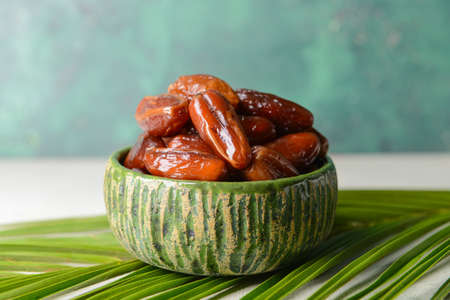 Bowl with sweet dates on table