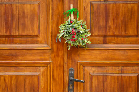 Mistletoe branch on wooden door, outdoorsの写真素材