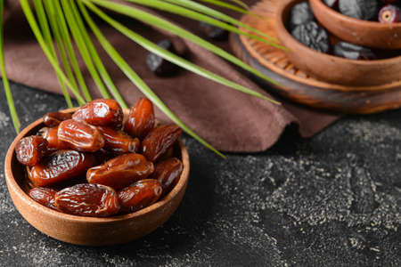 Plates with sweet dates on dark background