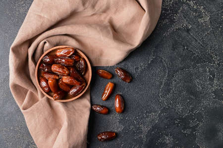 Plate with sweet dates on dark background