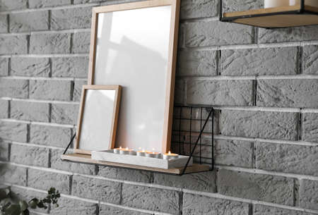 Shelf with burning candles in interior of roomの写真素材