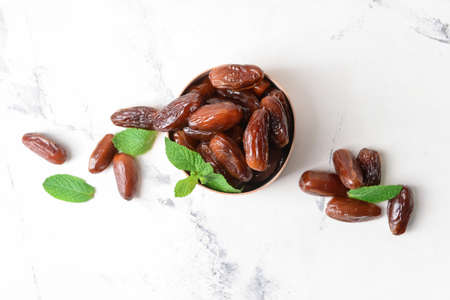 Box with sweet dates on light background