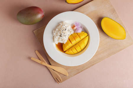 Plate with tasty rice and mango on color backgroundの写真素材