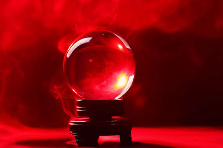 Crystal ball of fortune teller in smoke on color backgroundの写真素材