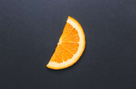 Slice of fresh orange on dark backgroundの写真素材