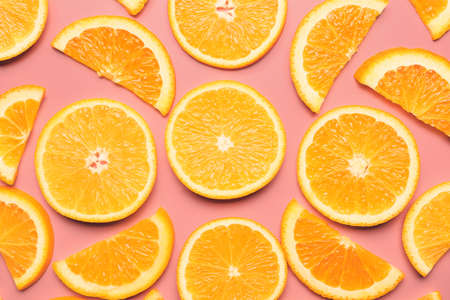 Slices of fresh oranges on color background