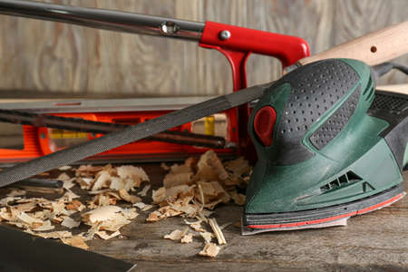 Set of carpenter's tools and saw dust on wooden background, closeup