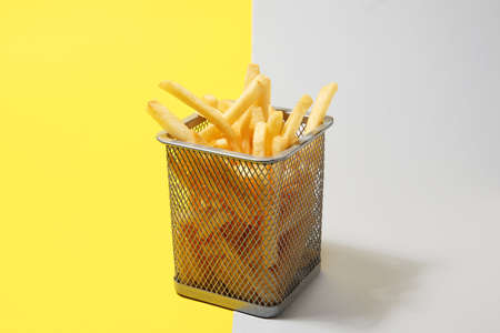 Box with tasty french fries on color backgroundの写真素材