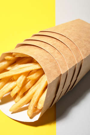 Boxes with tasty french fries on color backgroundの写真素材
