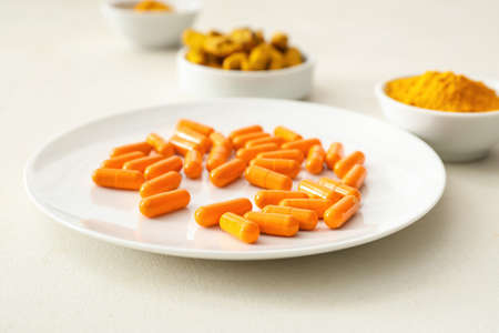 Plate with turmeric pills on table, closeupの写真素材