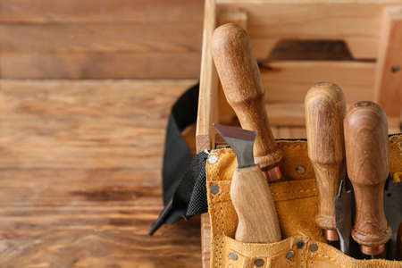 Belt with different carpenter's tools on wooden background, closeupの写真素材