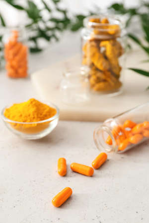 Turmeric pills, powder and roots on light backgroundの写真素材