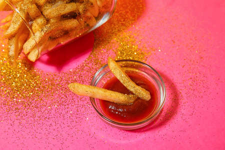 Creative composition with tasty french fries and sauce on color backgroundの写真素材