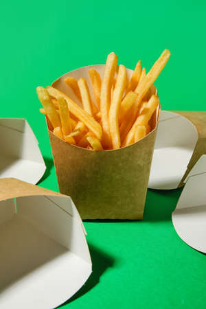 Boxes with tasty french fries on color backgroundの写真素材