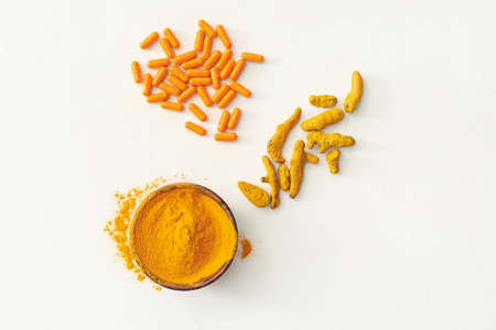 Turmeric pills, powder and roots on white backgroundの写真素材