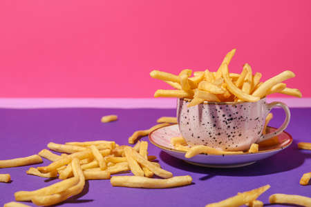 Cup with tasty french fries on color backgroundの写真素材