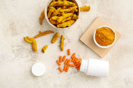Turmeric pills, powder and roots on light backgroundの写真素材