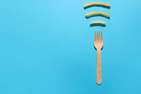 Creative composition with tasty french fries and fork on color backgroundの写真素材