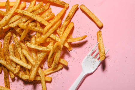 Glitters with tasty french fries and fork on color backgroundの写真素材