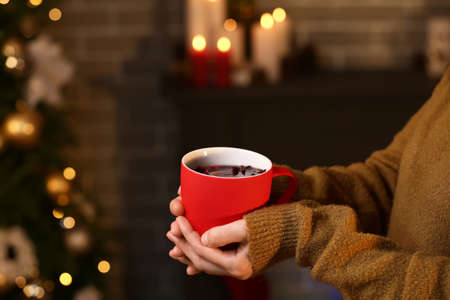 Woman drinking tasty mulled wine at home on Christmas eve