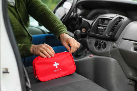 Man with first aid kit in carの写真素材