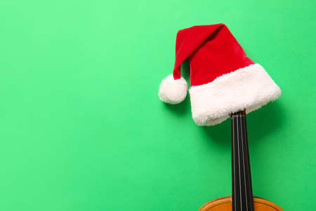 Violin with Santa Claus hat on color backgroundの写真素材