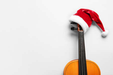 Violin with Santa Claus hat on light backgroundの写真素材